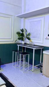 a table and stools with a potted plant on it at The Glory Apartment 3 in Imphal