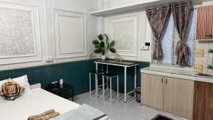 a bedroom with a bed and a kitchen with a table at The Glory Apartment 3 in Imphal