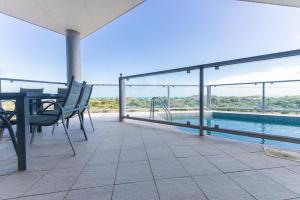 a patio with a table and chairs and a swimming pool at The Edge in Robe