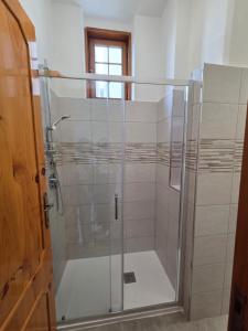 a shower with a glass door in a bathroom at Cosy Corner in Tollo