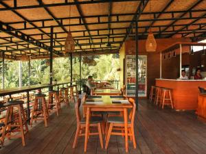a restaurant with wooden tables and chairs on a deck at The Garden Sanctuary Homestay in Sidemen