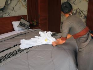 a man is cleaning a bed in a bedroom at The Garden Sanctuary Homestay in Sidemen +47 photos