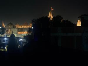 a city at night with a flag on top of a building at Devansh Palace Near Ram Mandir in Ayodhya +38 photos