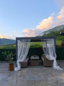 a gazebo with white curtains and a table and chairs at Etno Selo Relax in Šipovo +9 photos