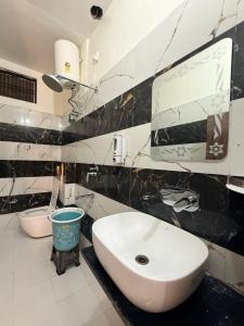 a black and white bathroom with a sink and a mirror at Devansh Palace Near Ram Mandir in Ayodhya