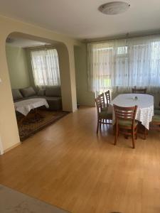 a living room with a table and chairs and a couch at Къща Бети самостоятелни апартаменти с двор край Пловдив in Skutare