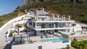 a house on the side of a hill with a swimming pool at Secret Oasis in Lefkogeia