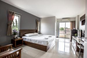 a bedroom with a bed and a large window at Central Place Serviced Apartment in Chon Buri