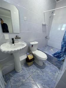a bathroom with a white toilet and a sink at Эмир in Pokrovka