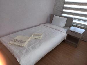 a small bedroom with a bed with two towels on it at Эмир in Pokrovka