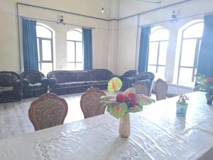 a room with a table with a vase with flowers on it at Эмир in Pokrovka