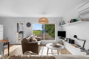 a living room with a couch and a table at No 5 Red Right on the beach! in Robe +16 photos