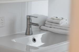 a bathroom sink with a faucet and some towels at No 5 Red Right on the beach! in Robe
