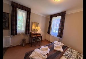 a bedroom with a bed and a desk and windows at Apartman Golf Lux in Bük +10 photos