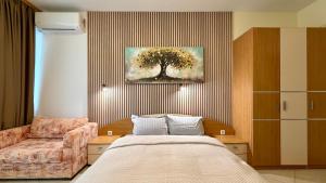 a bedroom with a bed and a painting of a tree at Premium Apartment Midia Beach in Sunny Beach