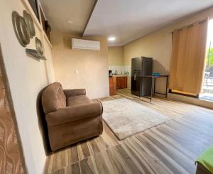 a living room with a chair and a refrigerator at Agujas hostel in Puerto Jiménez