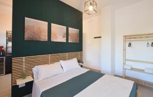 a bedroom with a bed and a green wall at Le Vele - Contro Fiocco in Rosolina +6 photos