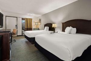 a hotel room with two beds and a television at Rodeway Inn Lumberton Central in Lumberton