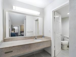a bathroom with a sink and a mirror at Rodeway Inn Lumberton Central in Lumberton +47 photos