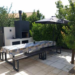 a picnic table with an umbrella and a grill at Villa Martina Bellevue in Šmrika