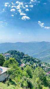 a view of a town from a hill with trees at AR Apartment in Khaira Gali