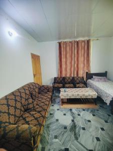 a living room with two beds and a couch at AR Apartment in Khaira Gali