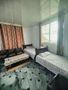 a room with three beds and a window at AR Apartment in Khaira Gali
