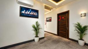 a hallway with two potted plants in front of a door at Hotel Grand Regency by JMD Group Near Delhi IGI Airport in New Delhi
