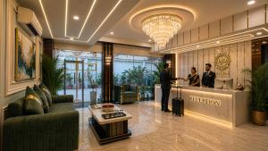 a lobby with two people standing at a reception counter at Hotel Grand Regency by JMD Group Near Delhi IGI Airport in New Delhi