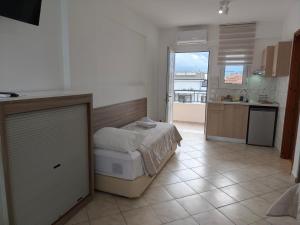 a small bedroom with a bed and a kitchen at Filomeni Studios in Pefkochori