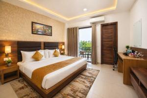 a bedroom with a large bed and a balcony at Hotel Grand Regency by JMD Group Near Delhi IGI Airport in New Delhi +12 photos