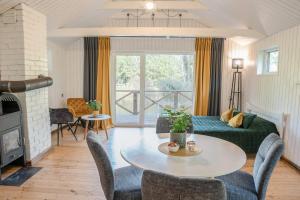 a living room with a table and a couch at Mežmadaras in Kuldīga
