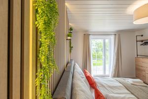 a bedroom with a couch and a plant on the wall at Boutique 54° Nord in Büsum