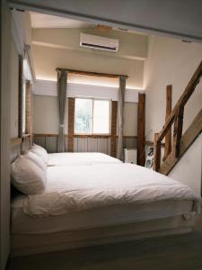 a bedroom with a large white bed with a window at 耶舍 yes sir 潛水旅宿1館2館 in Green Island