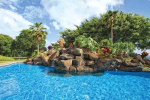 a resort swimming pool with a rock wall at Ka Eo Kai Resort Studio Suite in Princeville