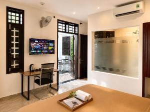 a living room with a desk and a tv on the wall at Unity Villa Staycation -Self Checkin in Hoi An