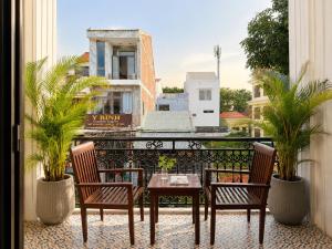 a patio with two chairs and a table on a balcony at Unity Villa Staycation -Self Checkin in Hoi An