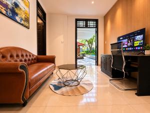 a living room with a leather couch and a table at Unity Villa Staycation -Self Checkin in Hoi An
