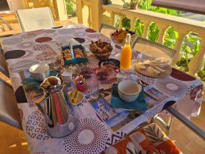 a table with a table cloth with food and drinks on it at Les Lauriers in Espondeilhan