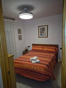 a bedroom with a bed with a orange comforter at Casa Irlia in García