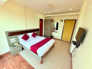 a bedroom with a bed and a flat screen tv at Hotel Kings Residency Panvel in Navi Mumbai