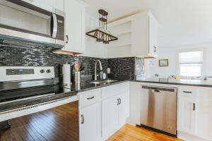 a kitchen with white cabinets and stainless steel appliances at Green on New in Staunton
