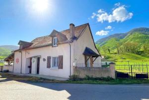 a white house with mountains in the background at Chez bourdet-pelou in Arette