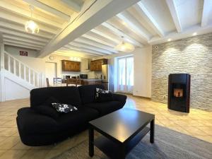 a living room with a black couch and a fireplace at Chez bourdet-pelou in Arette