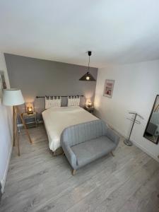 a bedroom with a bed and a chair and lights at Champoiseau in Tours