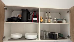 a cupboard filled with dishes and appliances at Ticallisti Rooms by Villa Lagkadaki in Agriliá