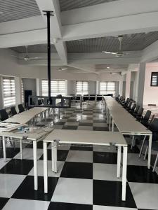 a large room with tables and chairs on a checkered floor at O Ansah Plaza Lodge in Kumasi