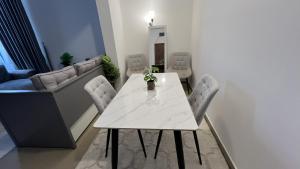 a dining room with a white table and chairs at Banny Homes - Cozy Suite Apartment - Downtown in Abu Dhabi