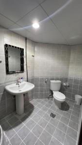 a bathroom with a white toilet and a sink at Banny Homes - Cozy Suite Apartment - Downtown in Abu Dhabi +28 photos