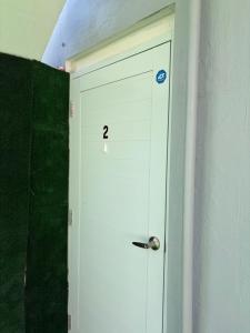 eine weiße Tür mit einer Nummer darauf in einem Zimmer in der Unterkunft Mini Studio Apartment in San Juan